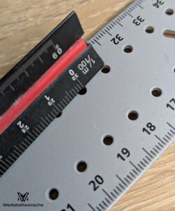 Lineal auf den Markierungslöchern eines Universalwinkels